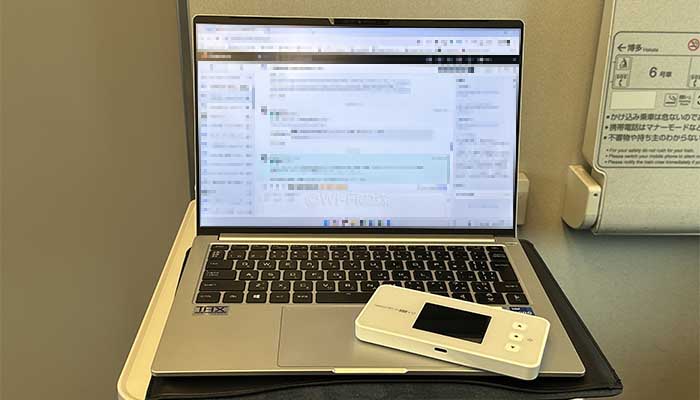 新幹線の移動中にWiMAXを使いながら仕事をしている写真